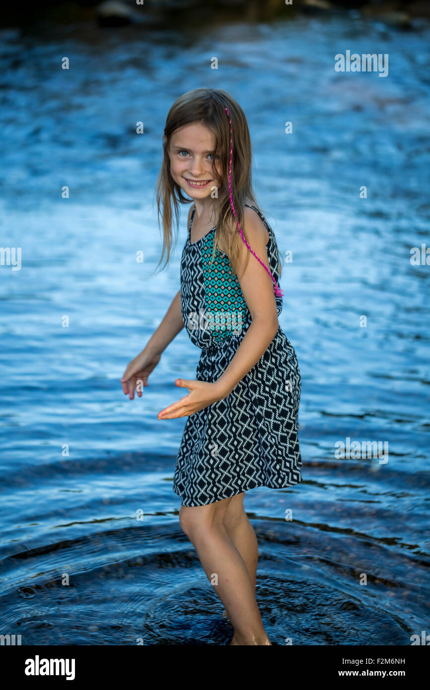 Portrait of smiling girl standing in water Stock Photo - Alamy