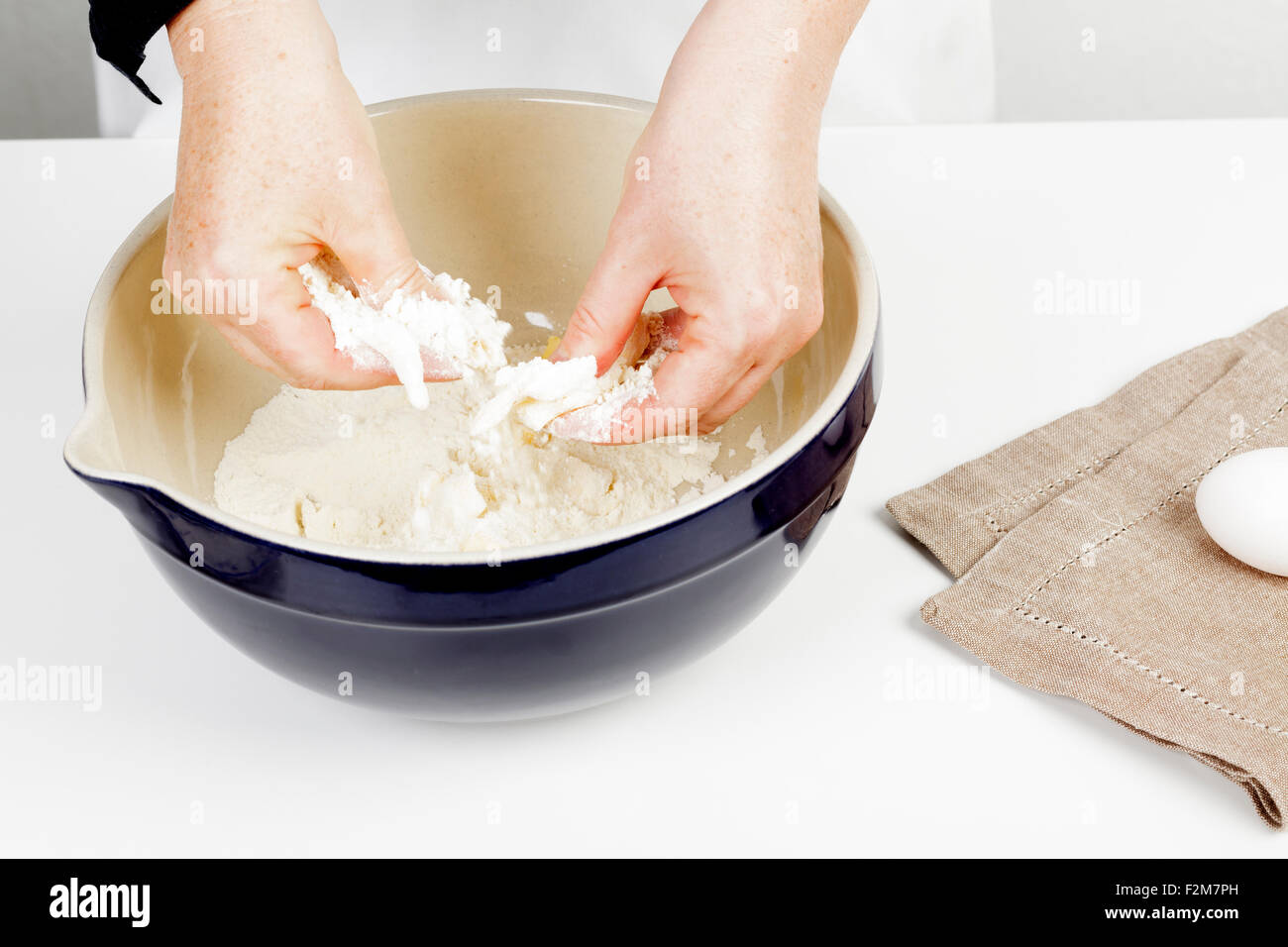 hands rubbing butter into flour Stock Photo