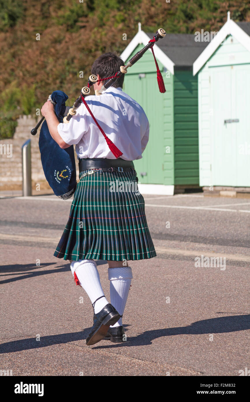 Piper playing bagpipes along promenade at Bournemouth in September Stock Photo