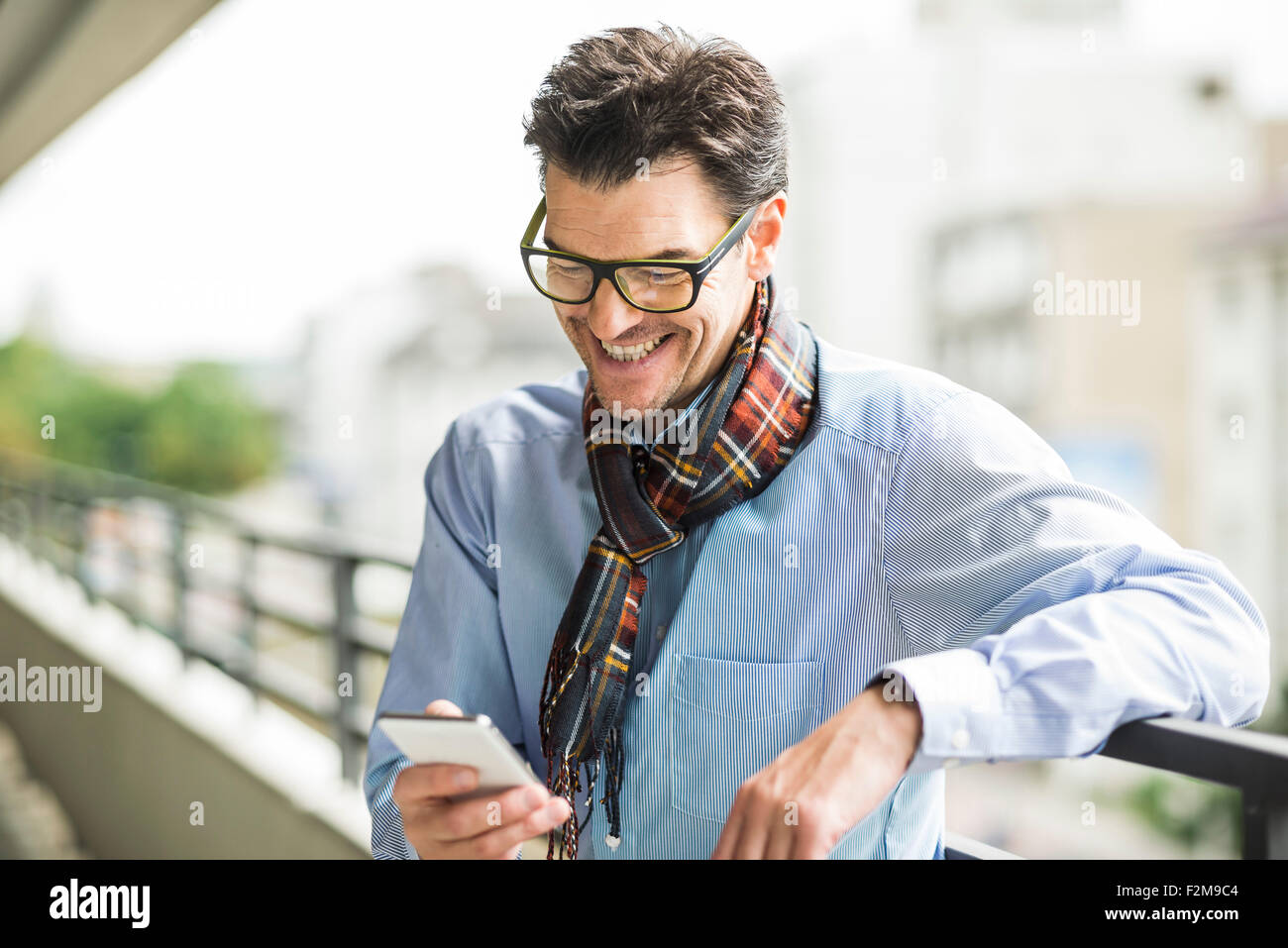 Smiling businessman looking at his smartphone Stock Photo