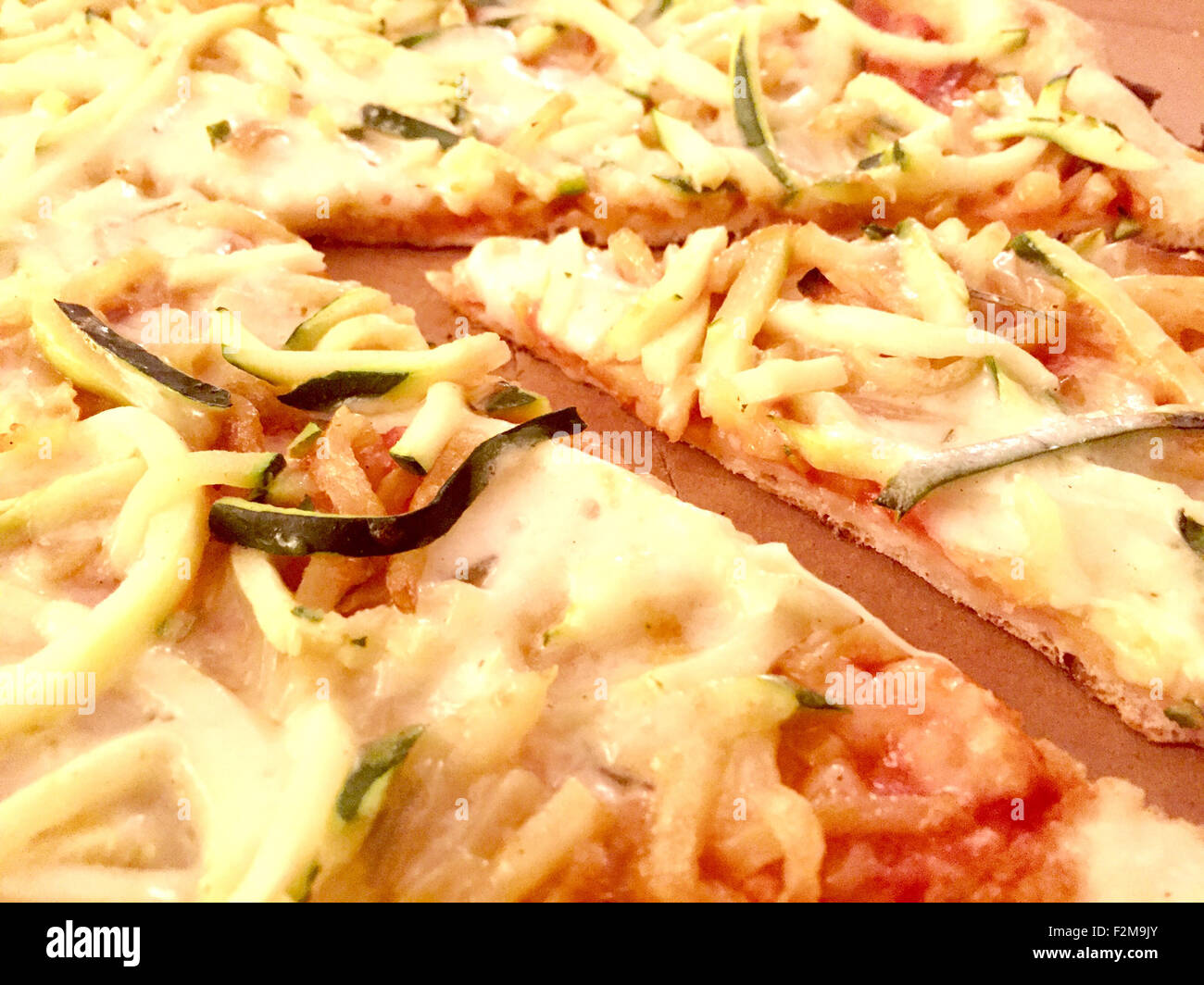 Aereal view of a slice of pizza with zucchini and potatoes cut  in thin slices in a cardoard box Stock Photo