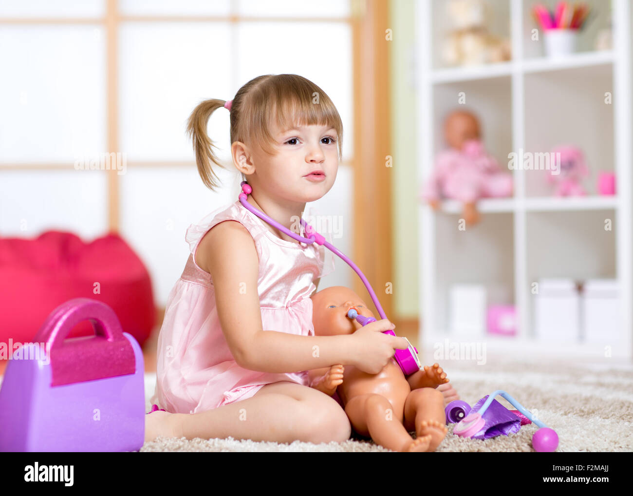 Little girl playing with dolls in hospital Stock Photo