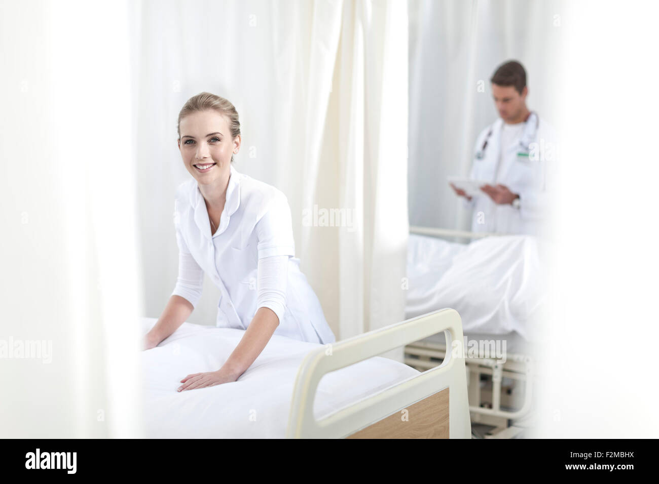 Smiling nurse making hospital bed Stock Photo Alamy