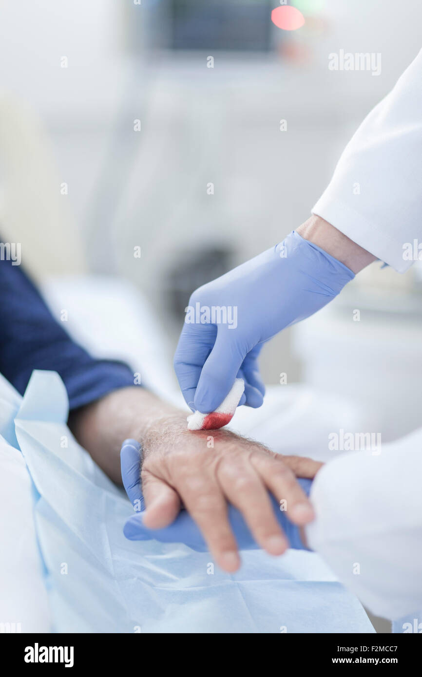 Nurse cleaning patient hand from IV drip Stock Photo Alamy