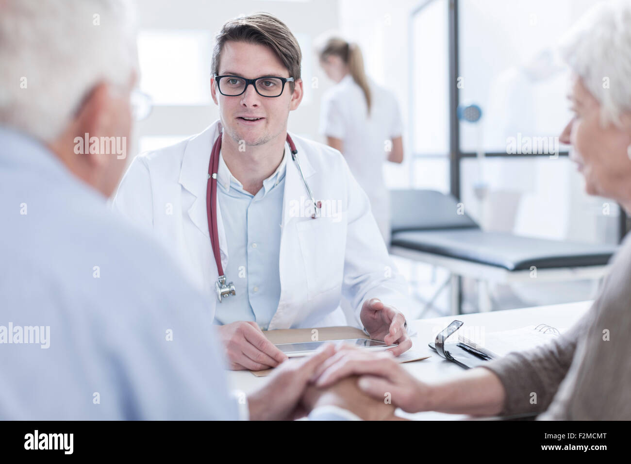Doctor advising couple hi-res stock photography and images - Alamy