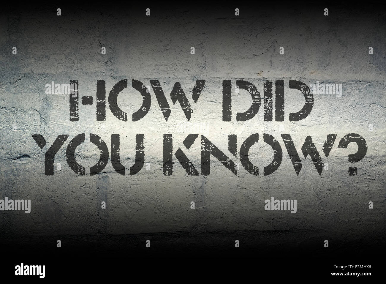 how did you know question stencil print on the grunge white brick wall Stock Photo