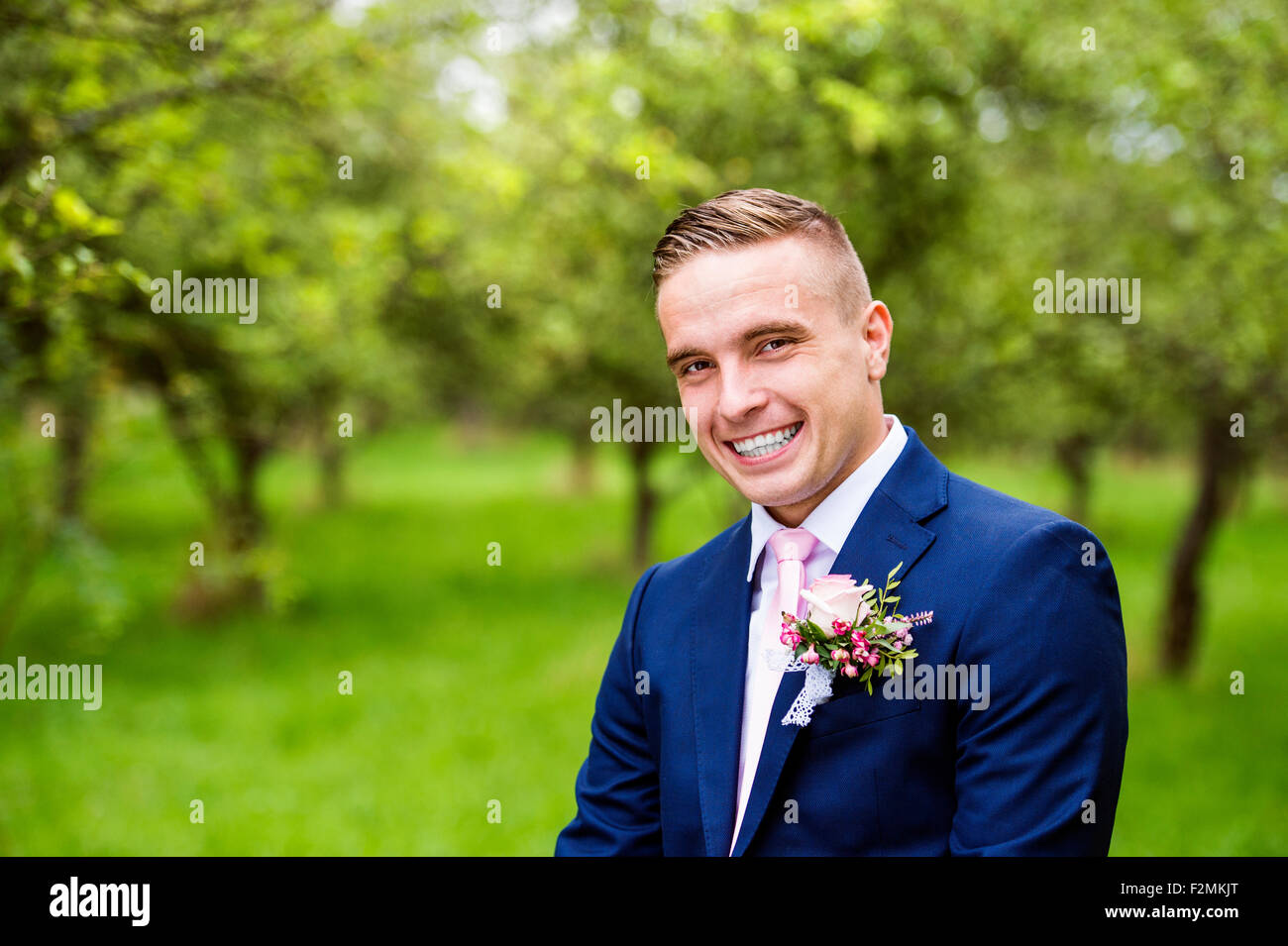 Handsome young groom posing outside in nature Stock Photo