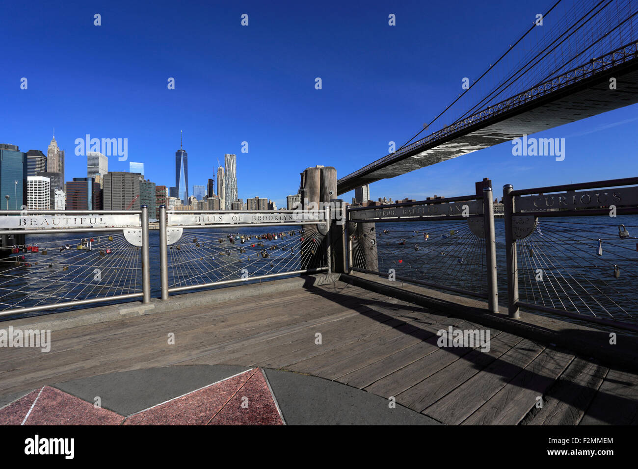The Brooklyn Bridge looking west towards Manhattan from Fulton Landing park Brooklyn Stock Photo