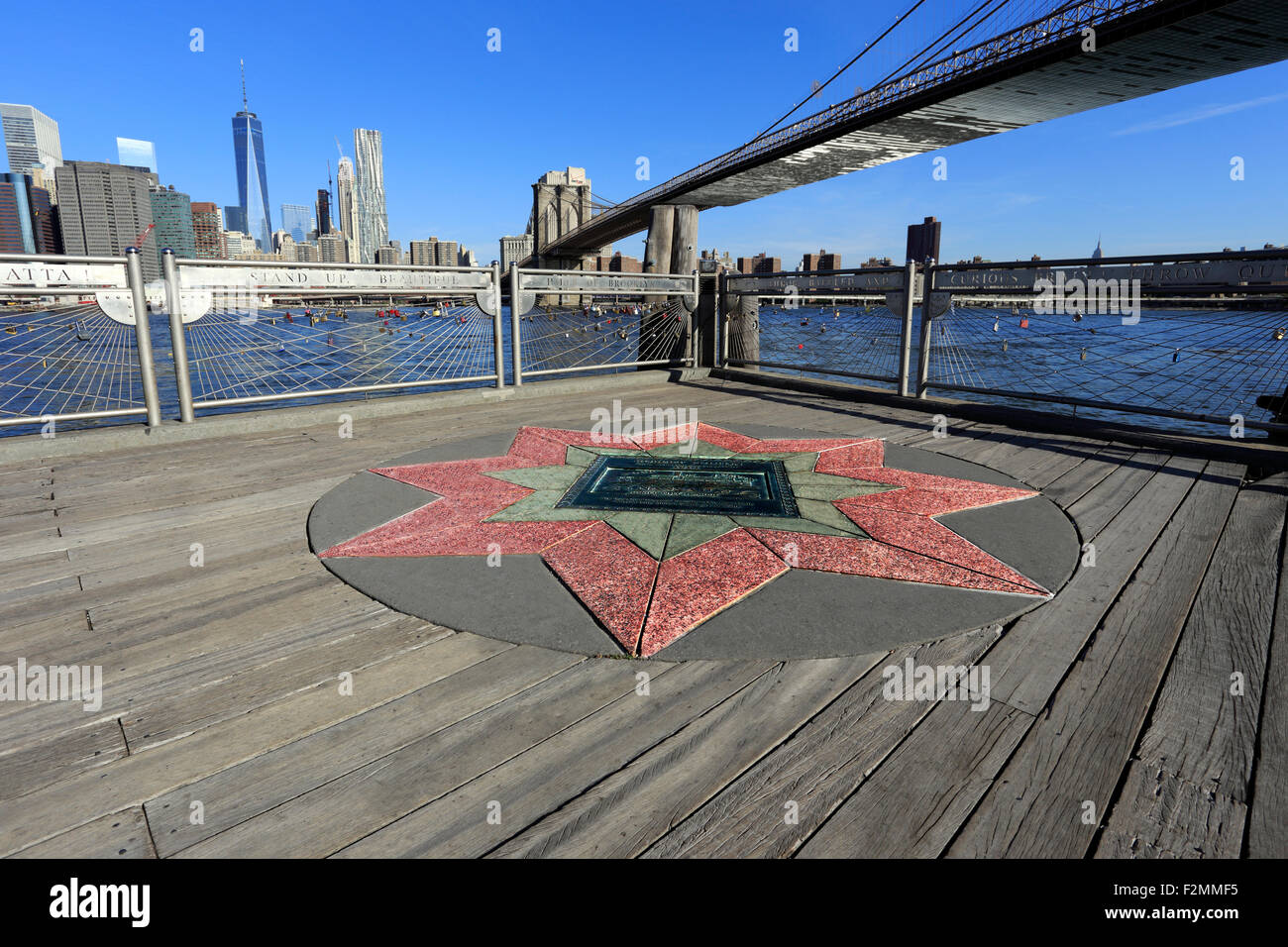 The Brooklyn Bridge looking west towards Manhattan from Fulton Landing park Brooklyn Stock Photo