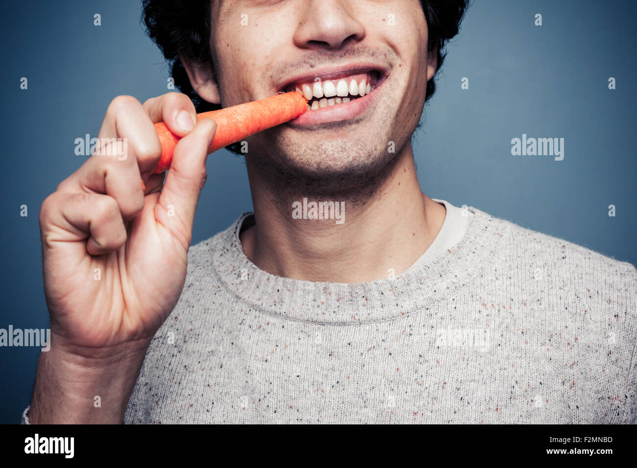 Man biting a carrot Stock Photo Alamy