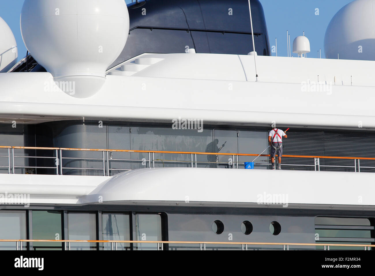 Luxury yacht being cleaned by unidentified crew member Stock Photo