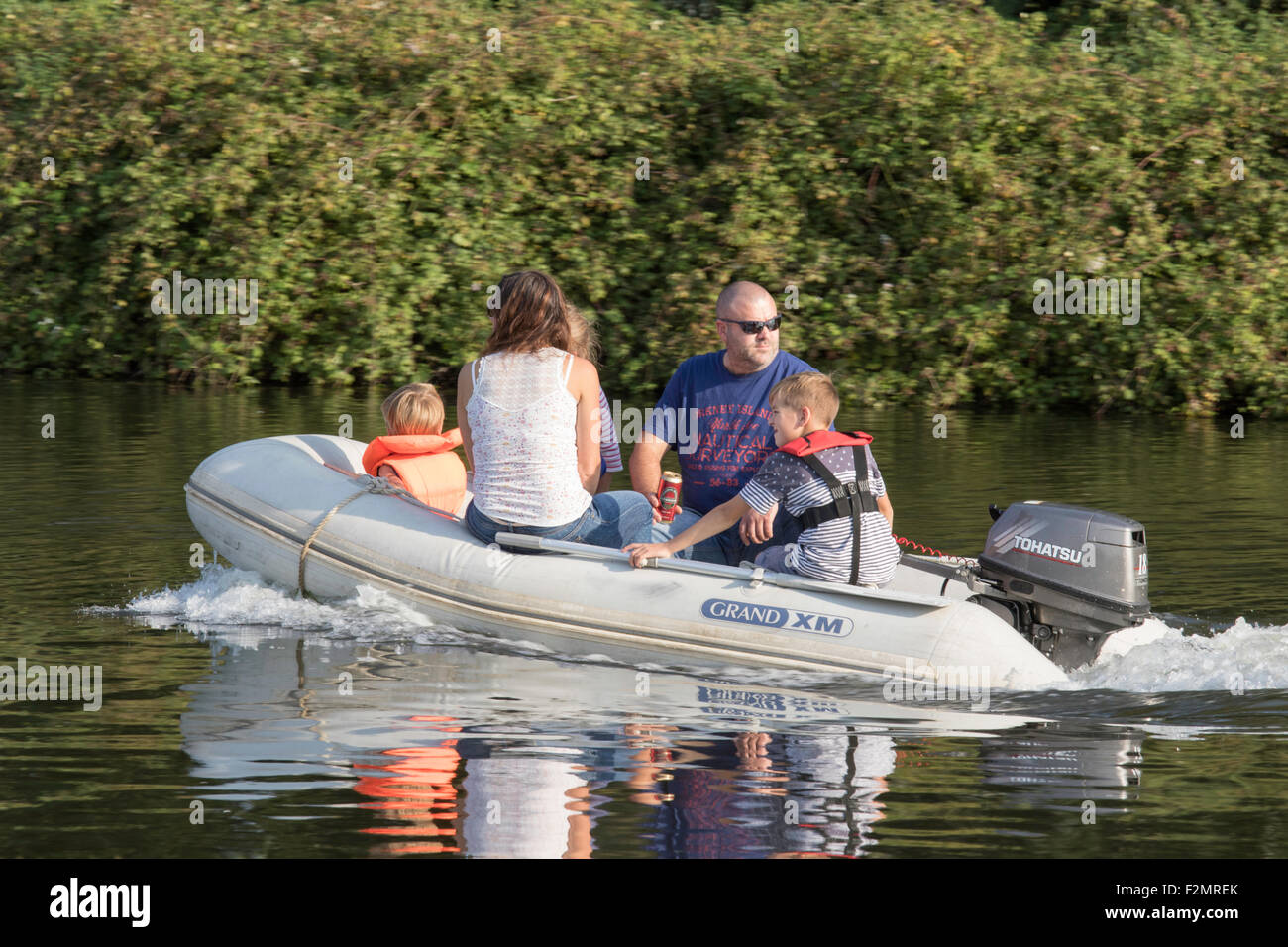 Family day out on a inflatable boat with the children wearing life jackets, England, UK Stock Photo