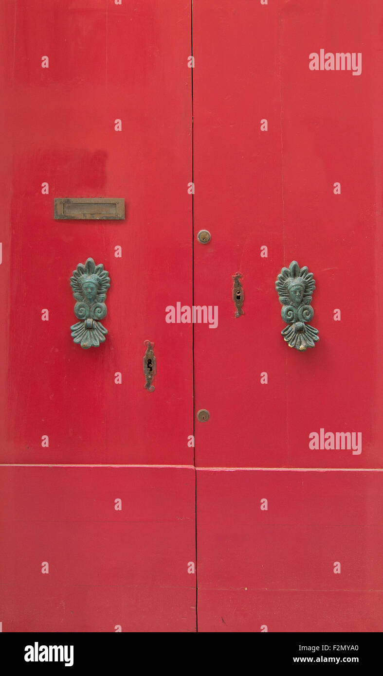 Red door with brass knobs. Painted doors of Malta series Stock Photo