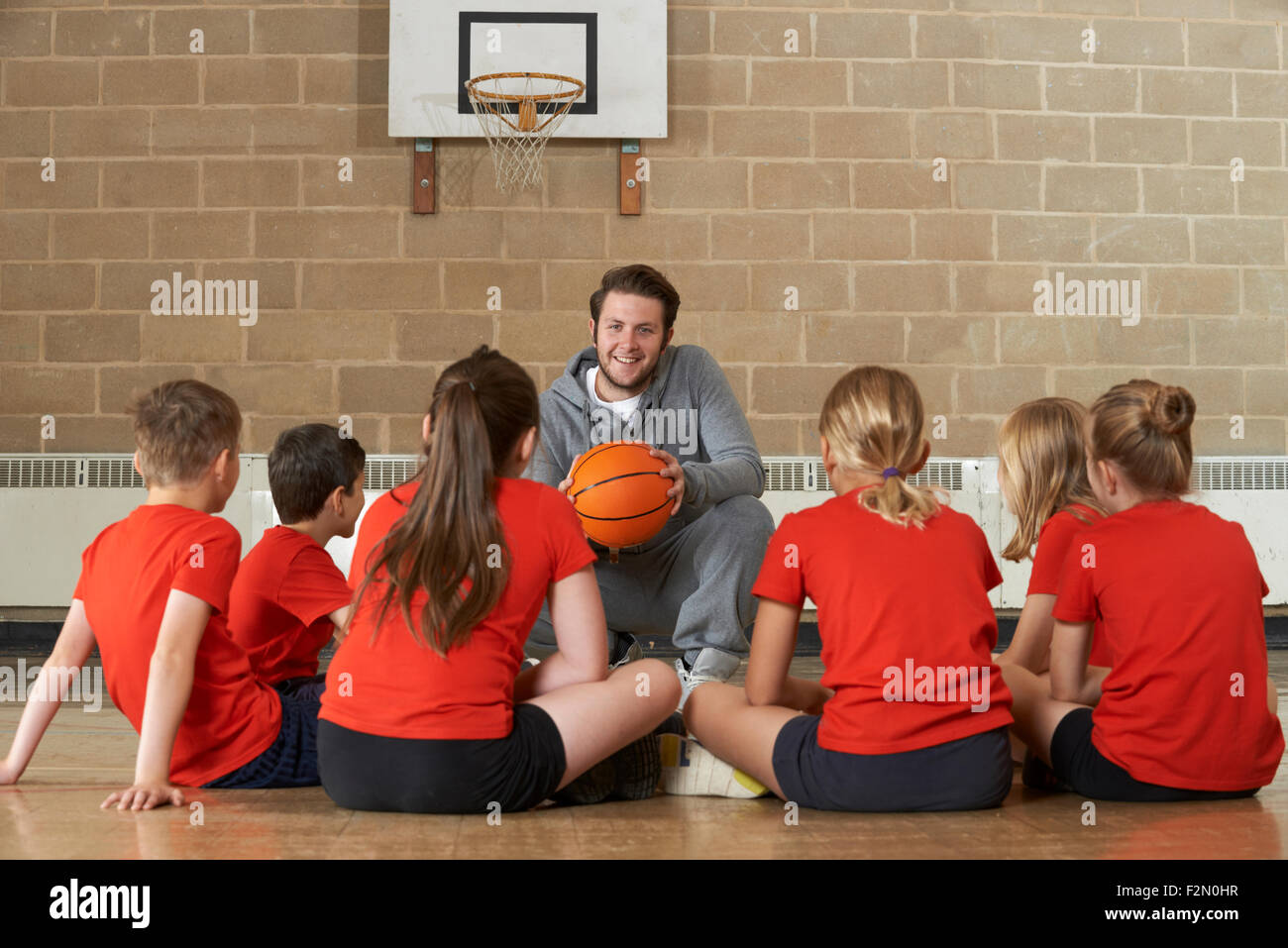 Coach Giving Team Talk To Elementary School Basketball Team Stock Photo