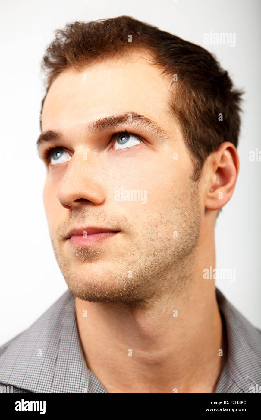 Face of serious man looking up over white Stock Photo