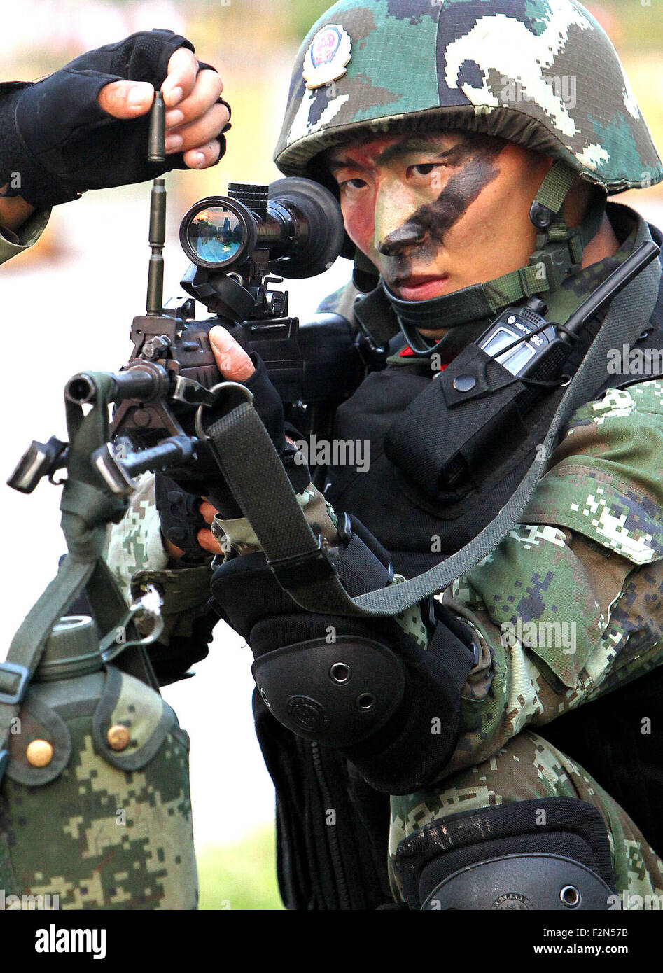 Shanghai, China. 21st Sep, 2015. Armed police sniper Liu Li tries to maintain stablility as his rifle is placed with shell casings during a drill in Shanghai, east China, Sept. 21, 2015. The emergency team of Pudong New Area Detachment of Armed Police Corps of Shanghai took part in an anti-terrorism drill on Sept. 21. © Chen Fei/Xinhua/Alamy Live News Stock Photo
