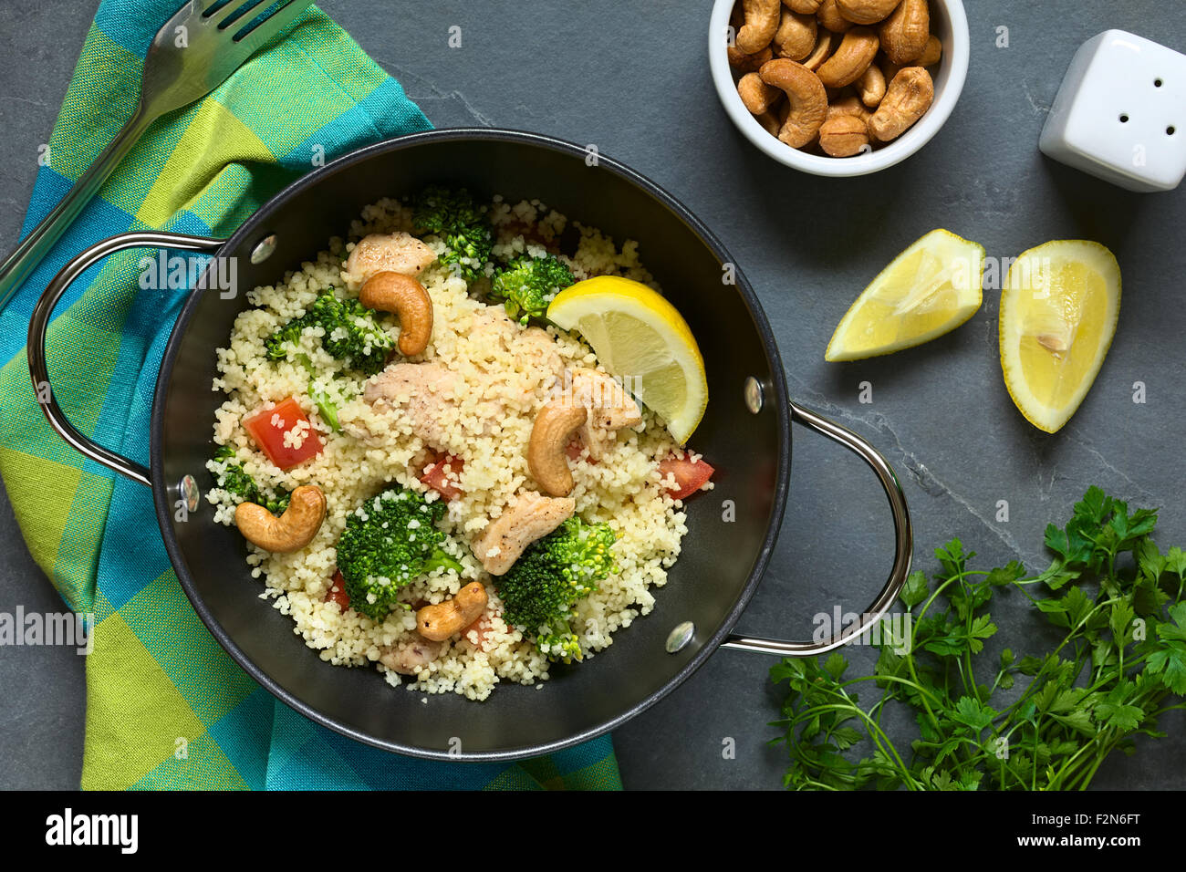 Couscous dish with chicken, broccoli, tomato, cashew nuts. Lemon