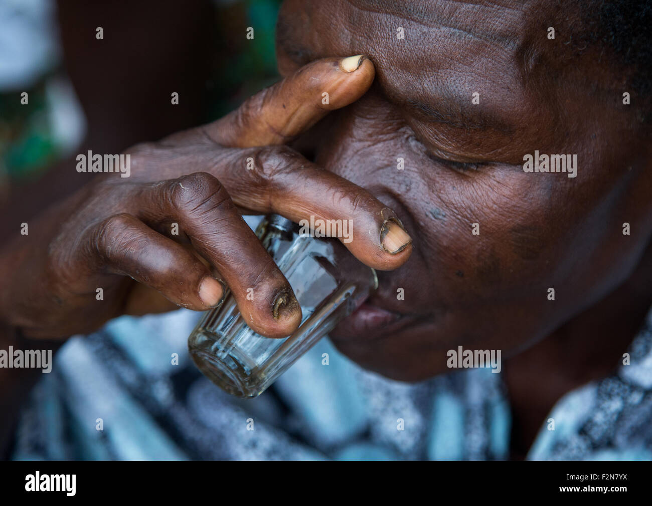 Benin, West Africa, Bopa, woman drinking alcohol during a voodoo ceremony Stock Photo