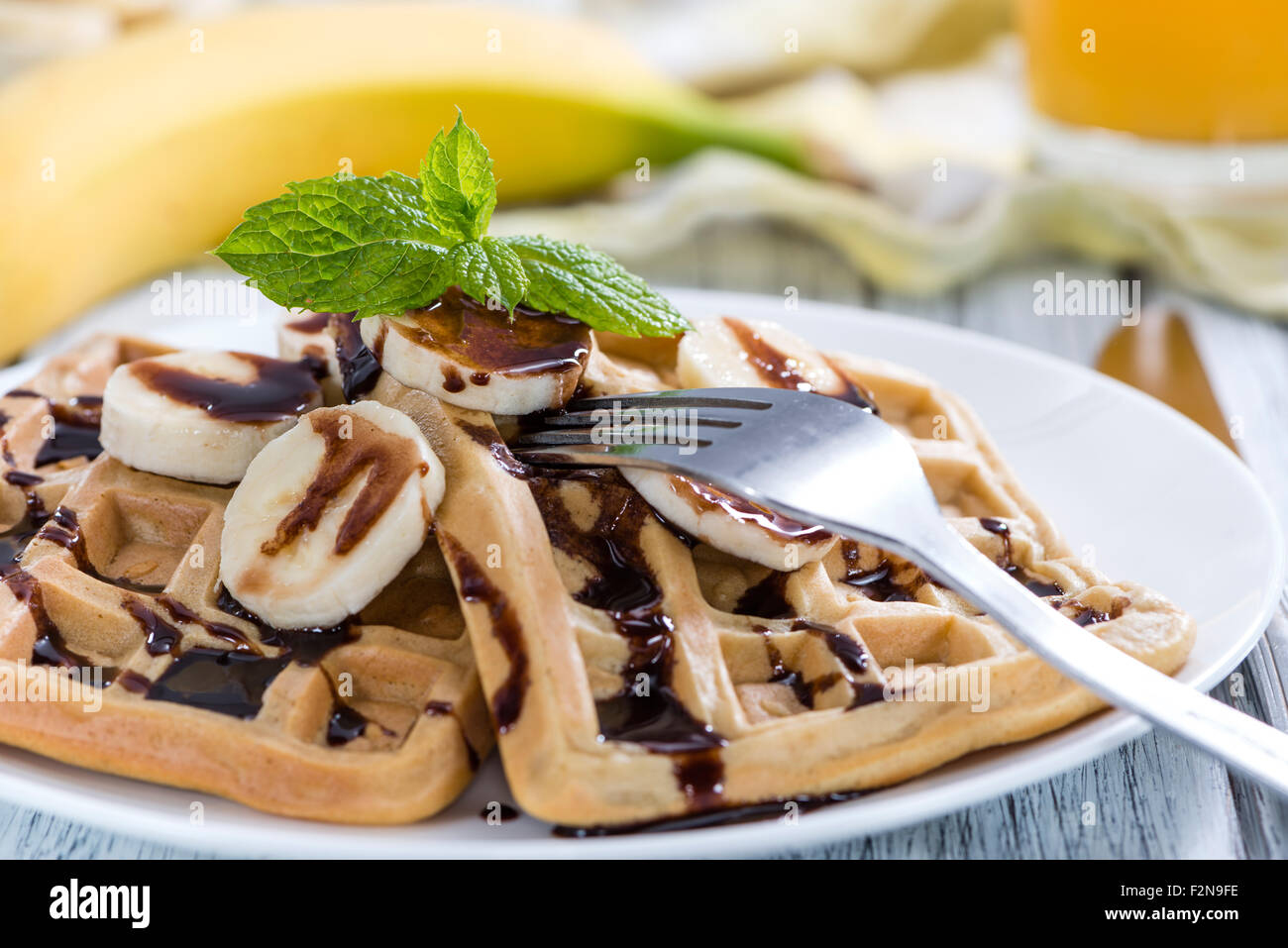 Breakfast table (Waffles with Bananas and Chocolate Sauce as close-up ...