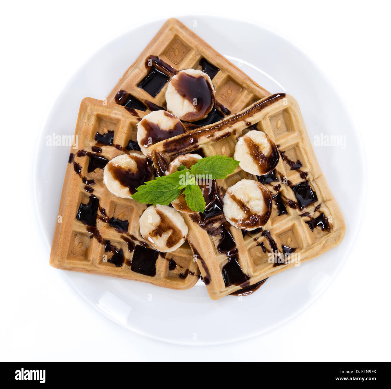 Waffles with Bananas and Chocolate Sauce (close-up shot) isolated on ...