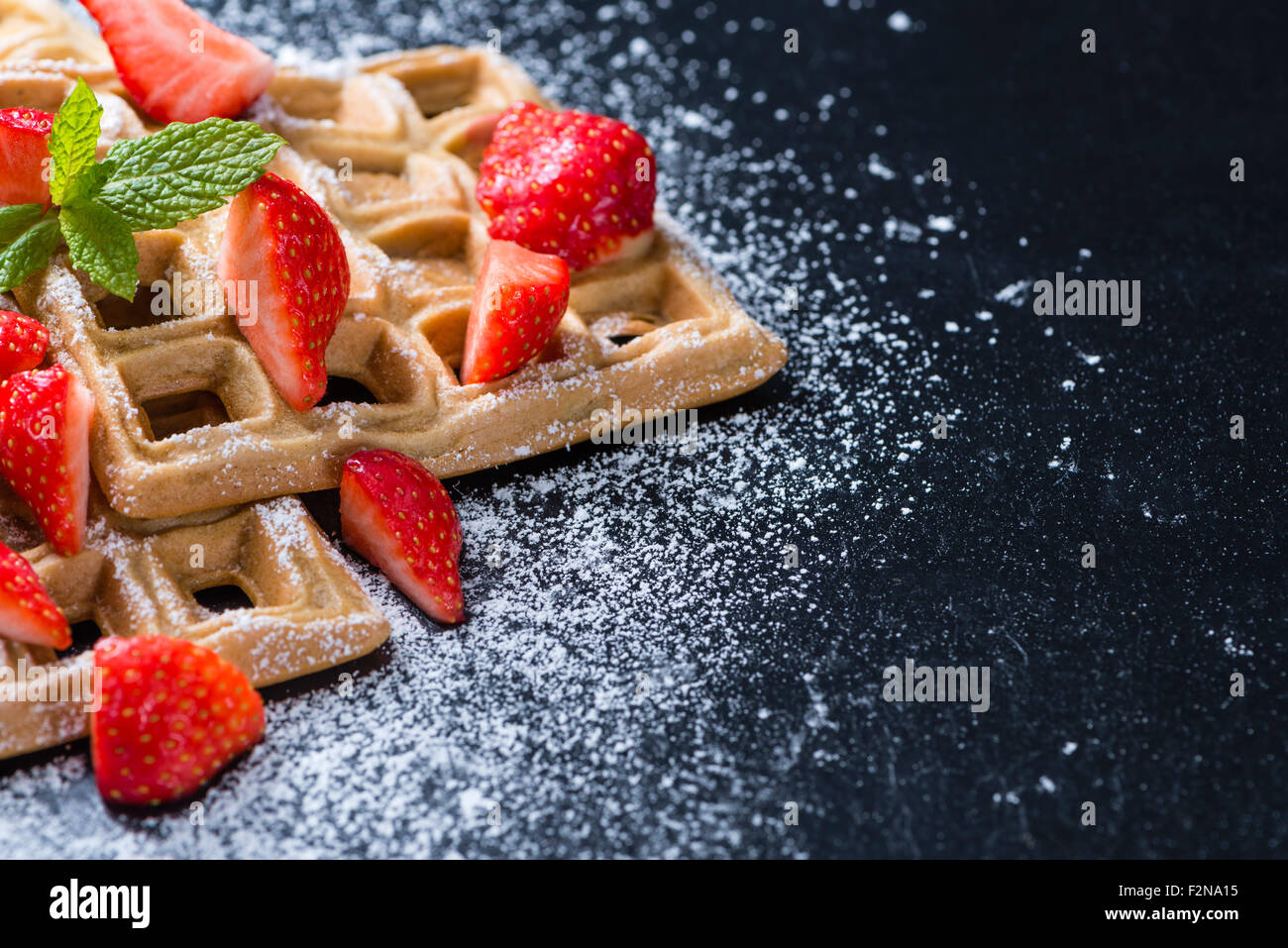 Homemade Waffles with fresh Strawberries (on dark background) Stock Photo