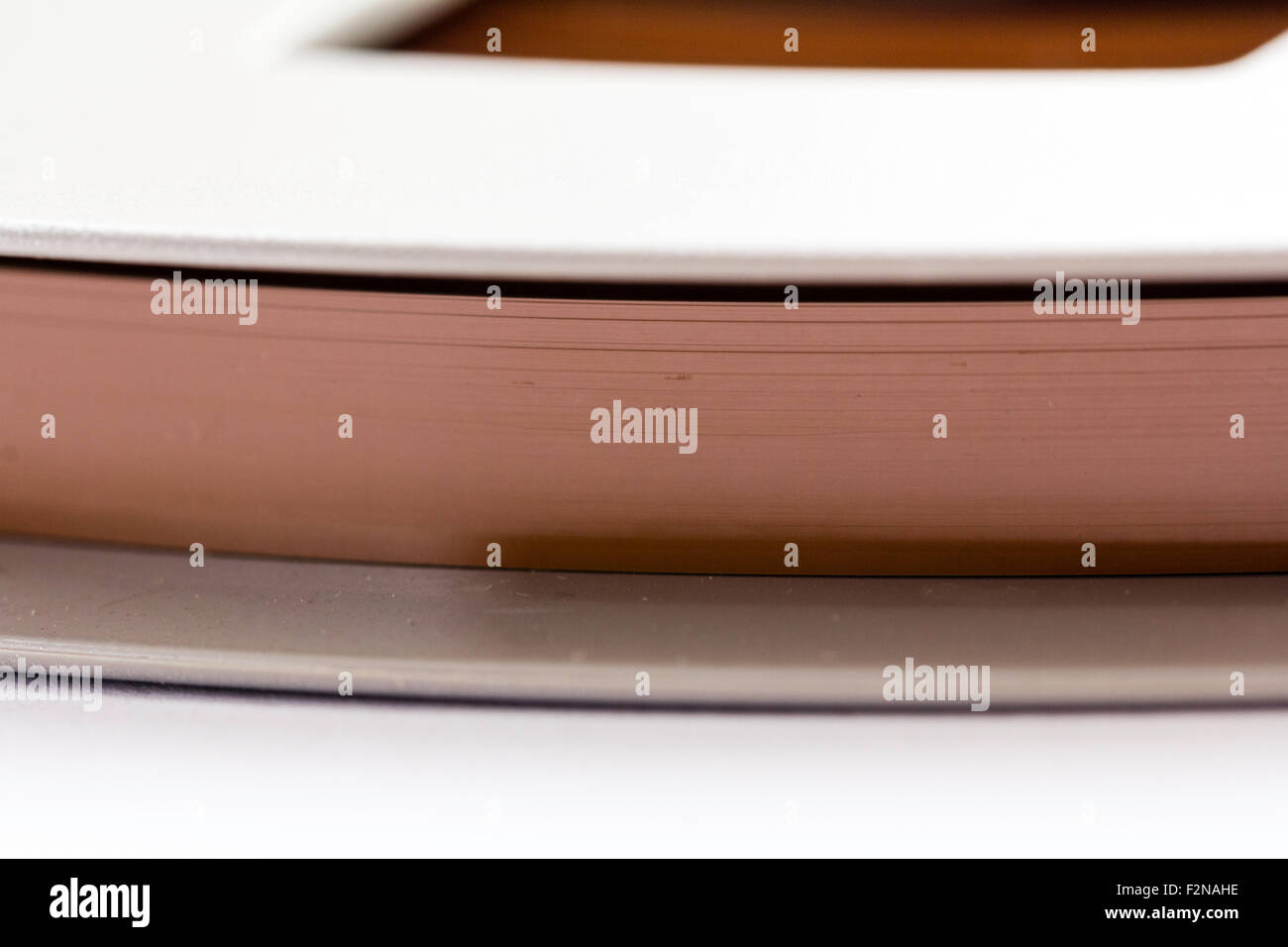 Spool of magnetic recording reel to reel tape. Spool is light grey, tape is  brown. Close up of tape wound on part of the spool Stock Photo - Alamy