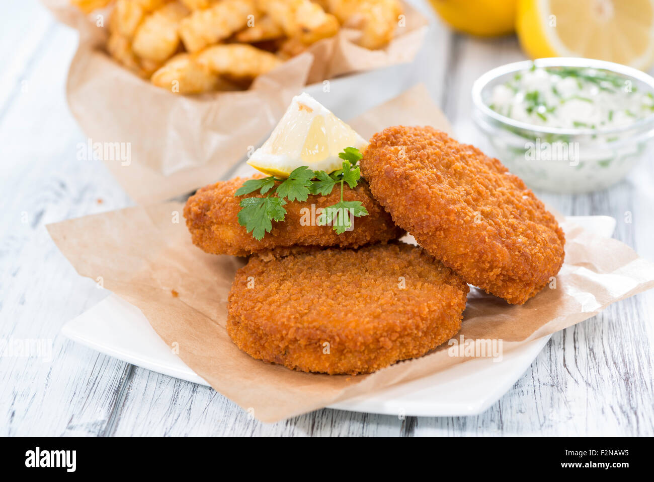 Fishburger with fresh made Chips and remoulade Stock Photo