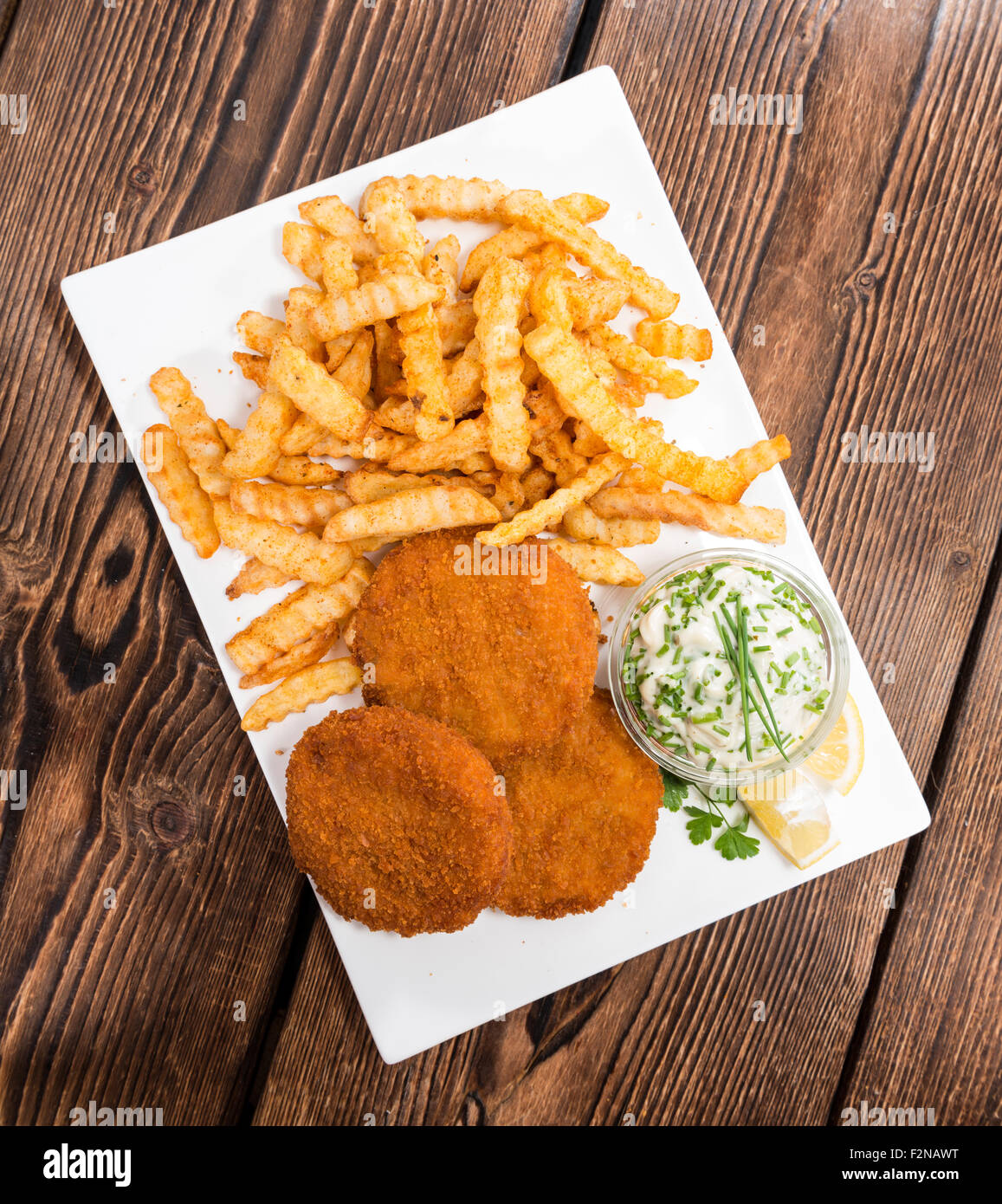 Fishburger with fresh made Chips and remoulade Stock Photo