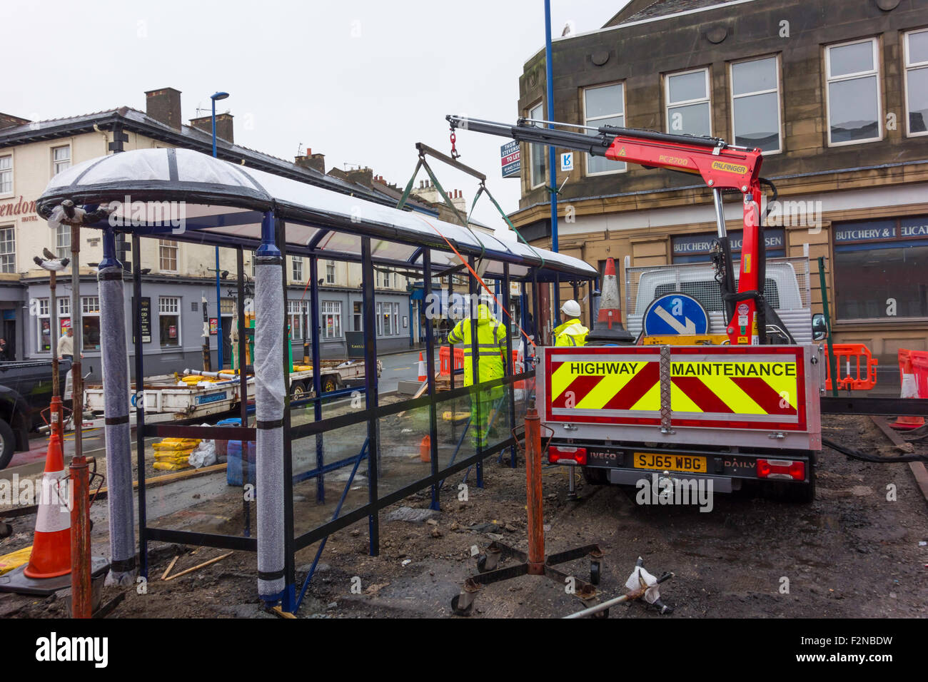 Workman installing a new bus shelter in Redcar Cleveland North Yorkshire England UK Stock Photo