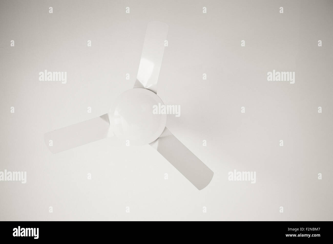 Fan on white ceiling in black and white with copy space Stock Photo