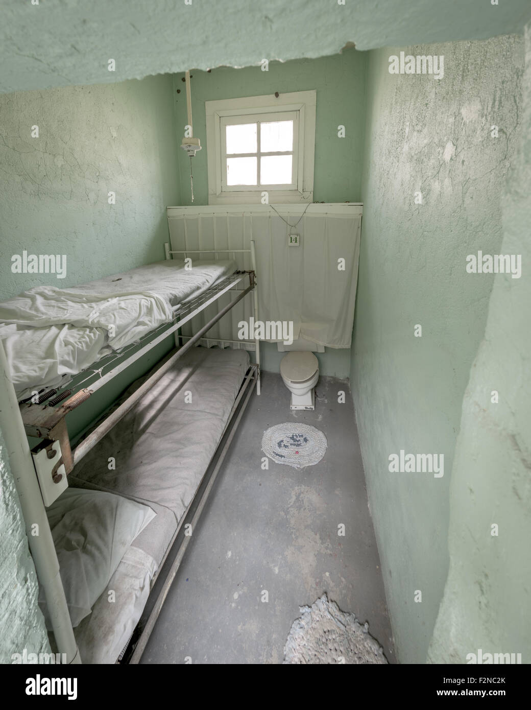 Old prison cell with bunk beds Stock Photo