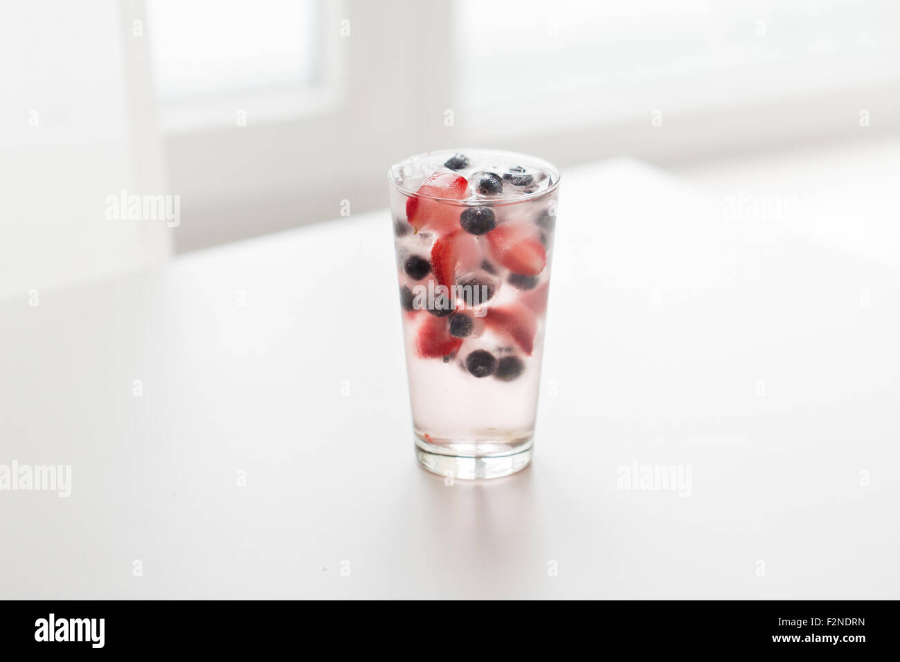 close up of fruit water with ice cubes in glass Stock Photo - Alamy