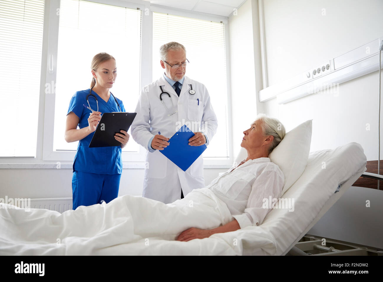 doctor and nurse visiting senior woman at hospital Stock Photo - Alamy