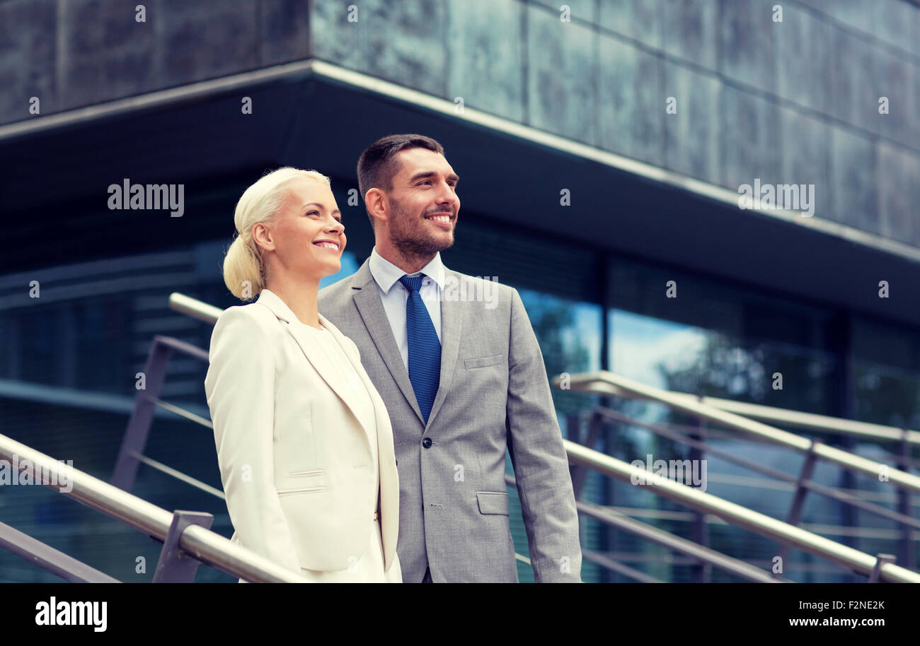 smiling businessmen standing over office building Stock Photo - Alamy