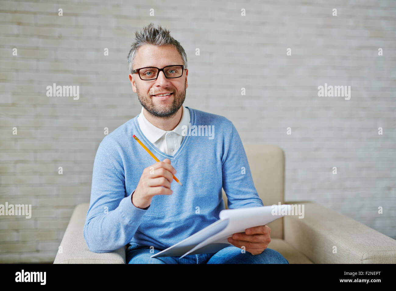 Male psychiatrist with pencil and clipboard looking at camera Stock Photo
