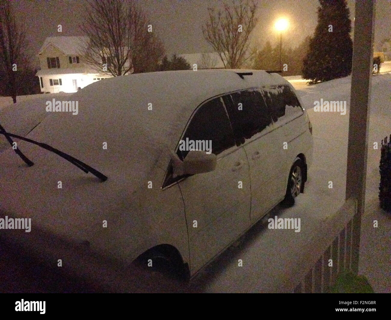Snow pile on parked car in driveway Stock Photo