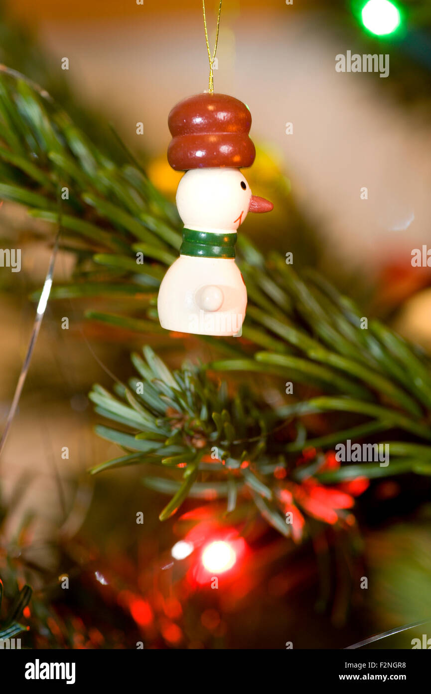 a cute and fun wooden painted christmas tree decoration in the shape of a snowman wearing a huge hat. Stock Photo