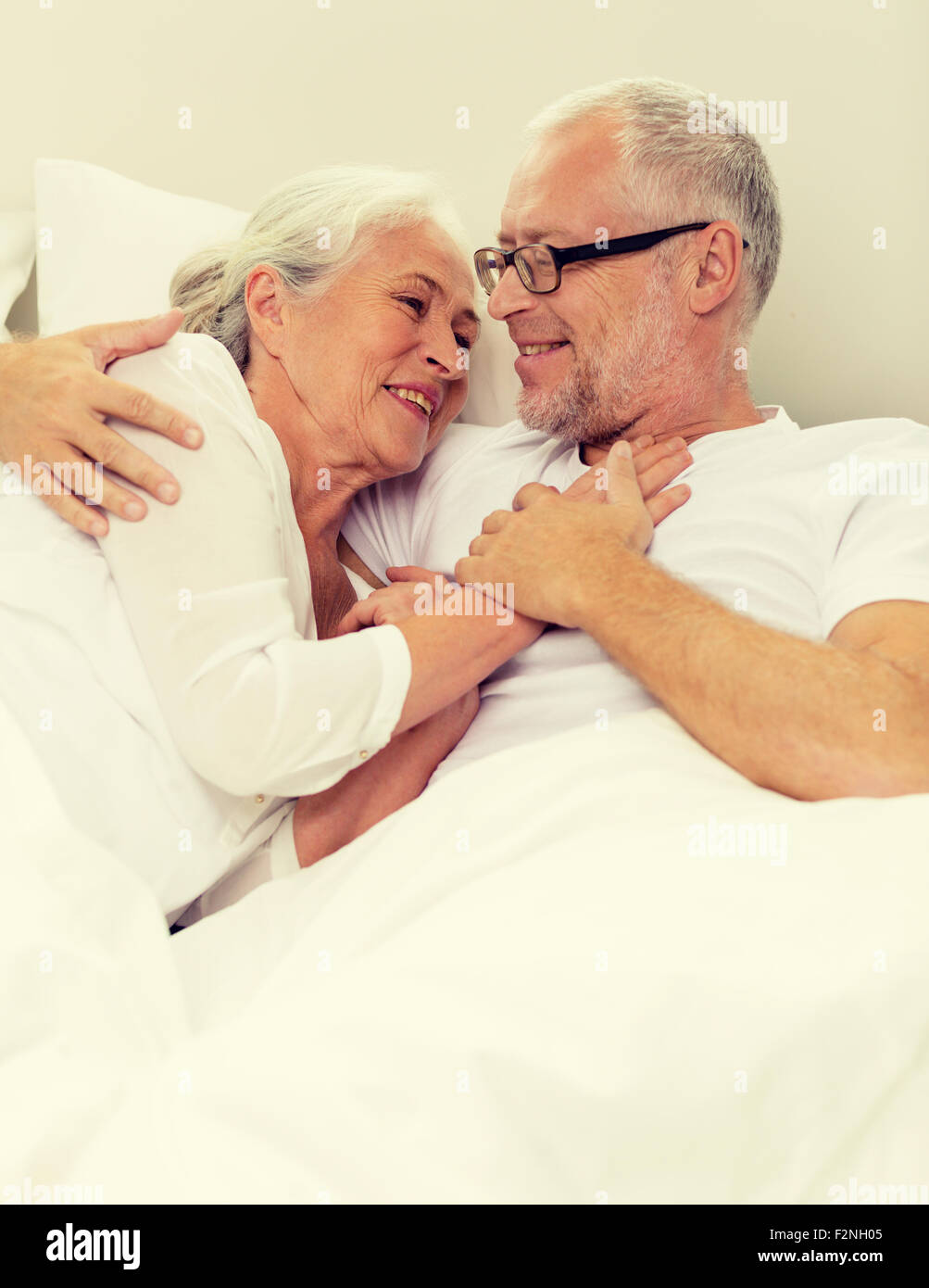 Old couple embracing in bed hi-res stock photography and images - Alamy