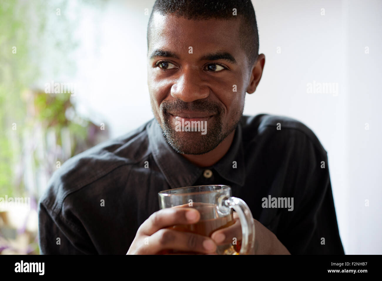 Black man drinking cup of tea Stock Photo
