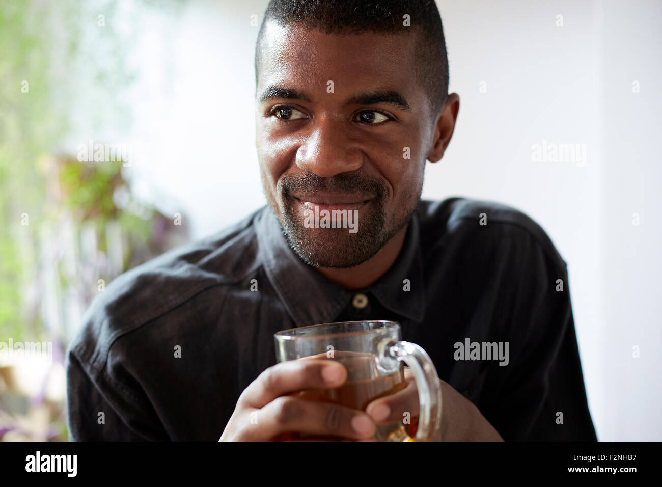 Black man drinking cup of tea Stock Photo - Alamy