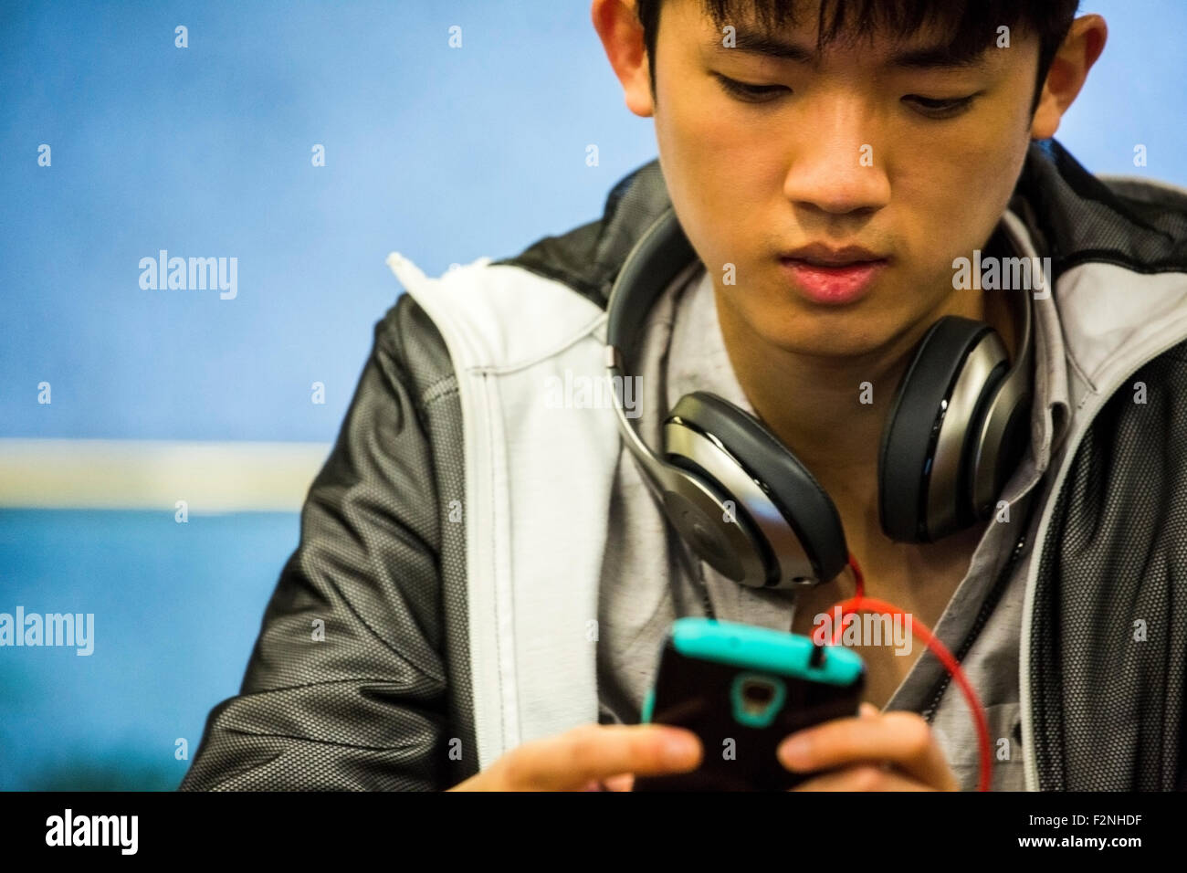 Asian man with headphone using cell phone Stock Photo