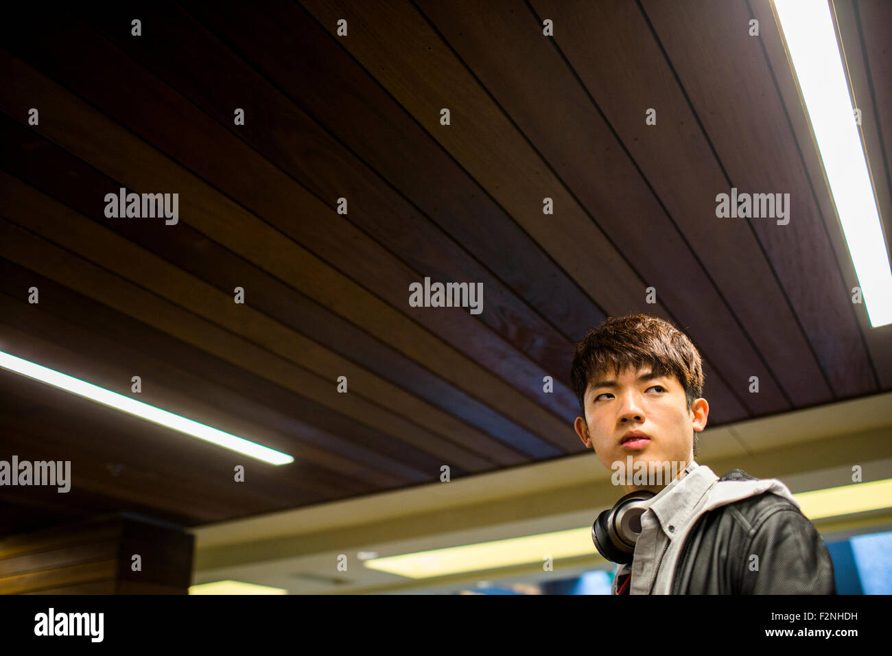 Asian man walking under wooden ceiling Stock Photo