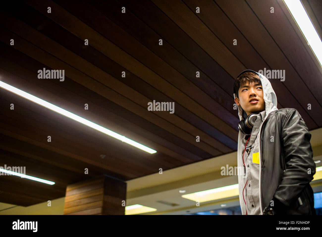 Asian man walking under wooden ceiling Stock Photo