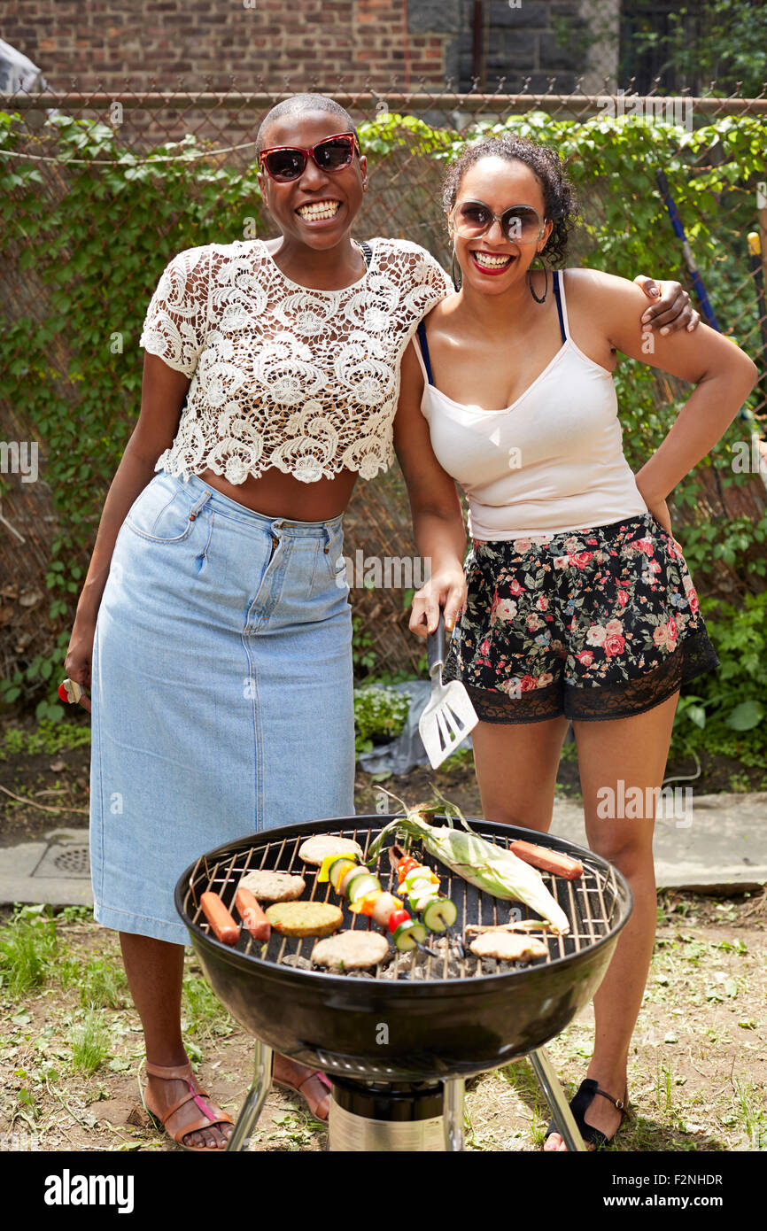 Women grilling vegetables at backyard barbecue Stock Photo