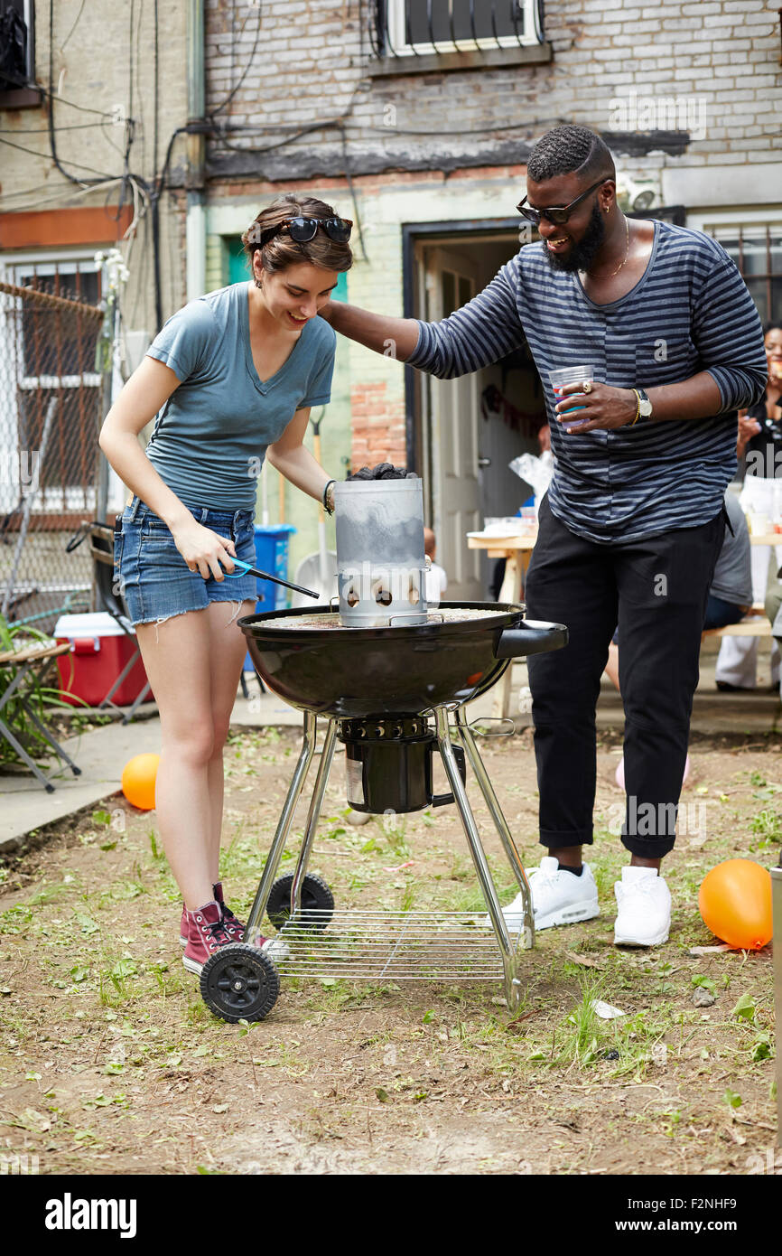 Couple lighting charcoal for backyard barbecue Stock Photo Alamy