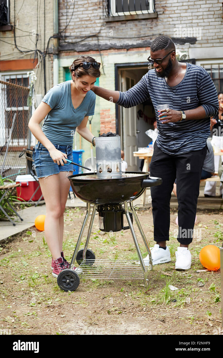 Couple lighting charcoal for backyard barbecue Stock Photo
