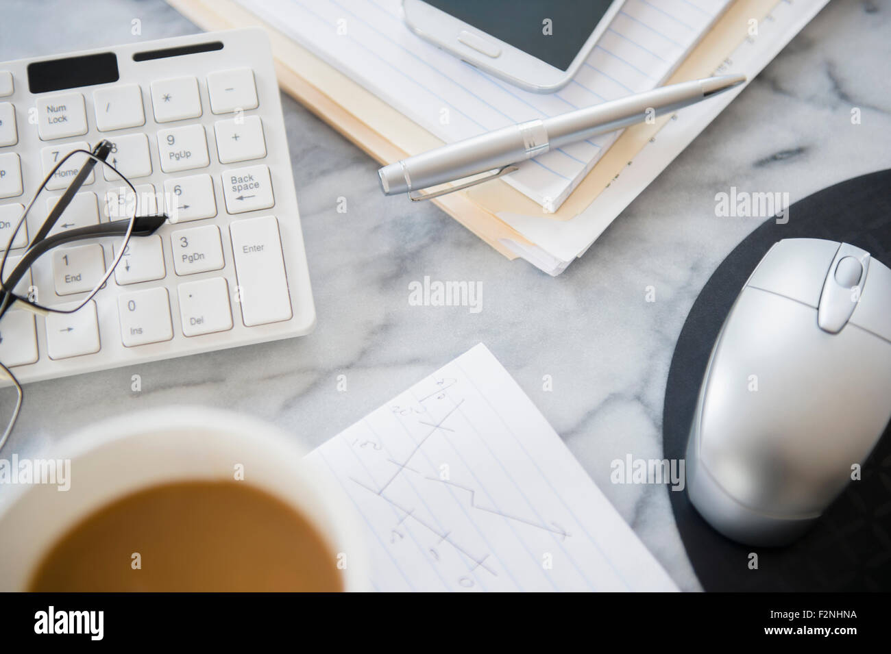Close up of computer equipment, files and coffee on office desk Stock Photo