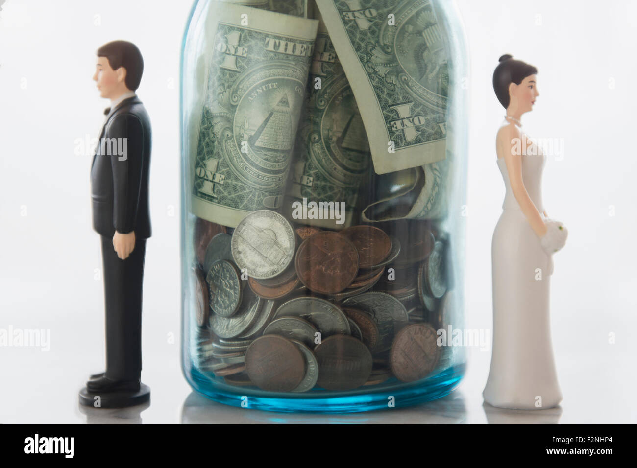 Close up of bride and groom dolls near savings jar Stock Photo