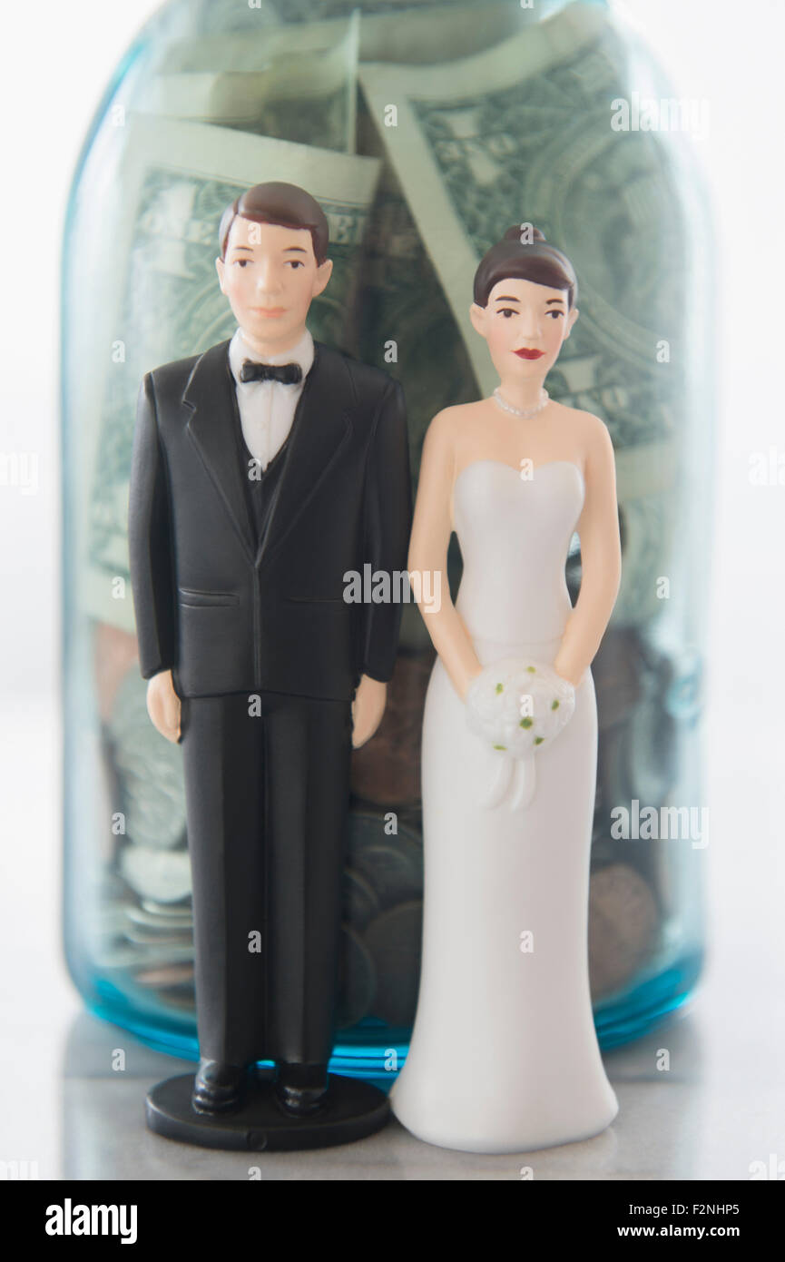 Close up of bride and groom dolls near savings jar Stock Photo