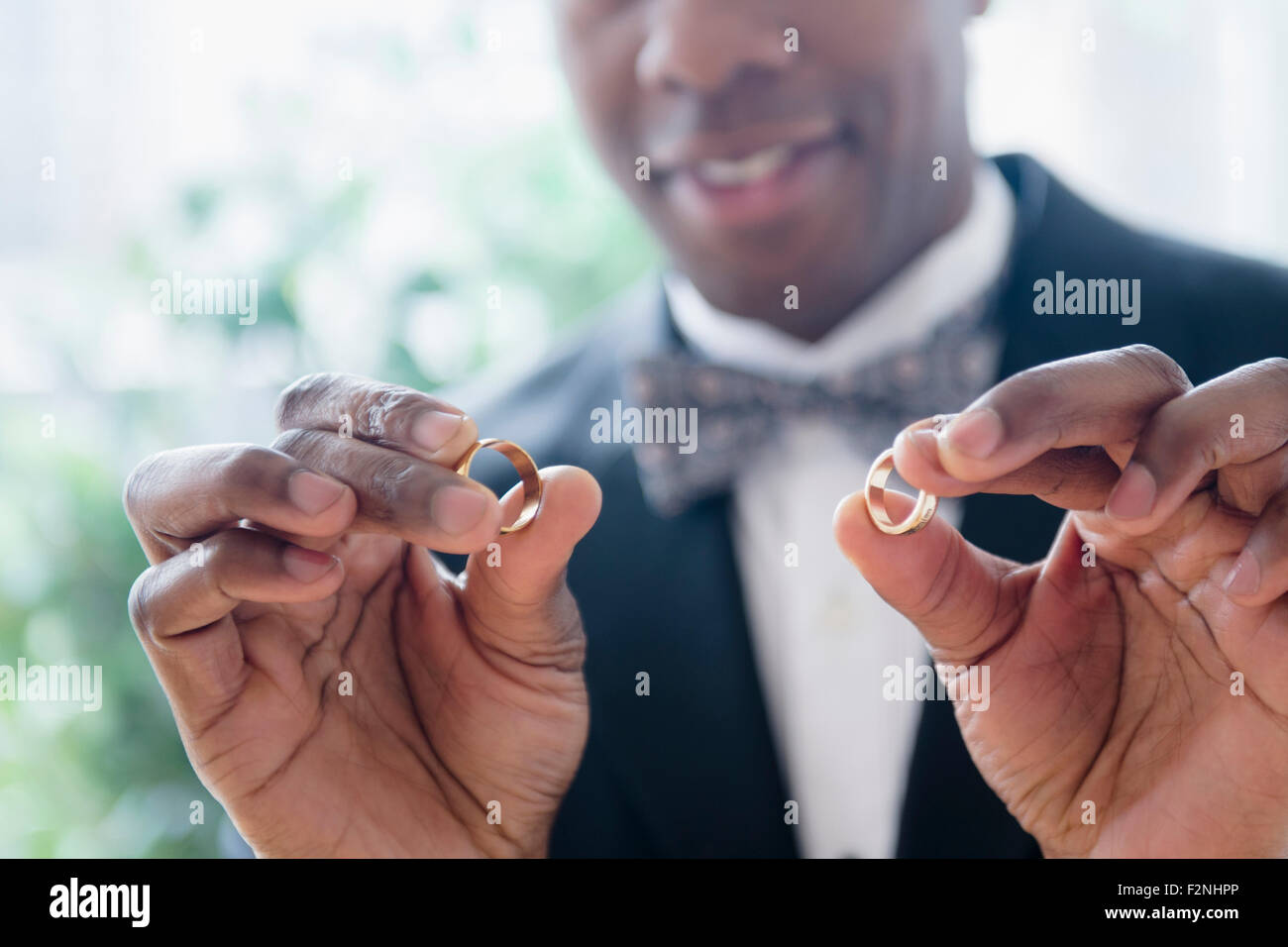 Close up of groom holding wedding rings Stock Photo